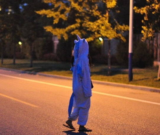 walking in the street wearing a purple onesie