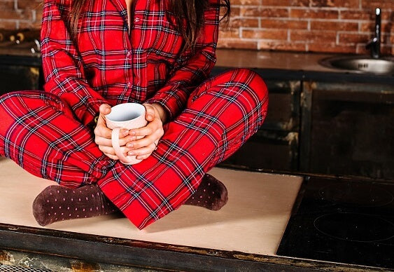 woman with fleece pyjamas sitting with mug