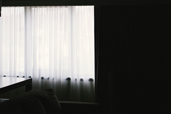 half drawn blackout curtain in dark room