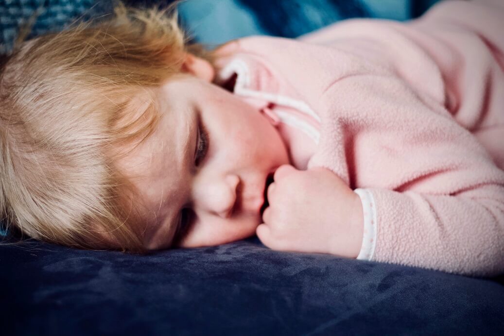 kid sleeping in pink pyjamas